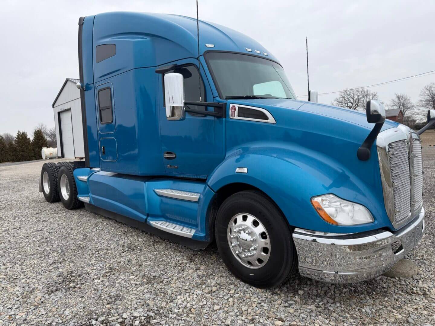 Blue sleeper semi truck parked on gravel